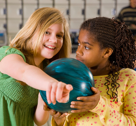 Two girls bowling.
